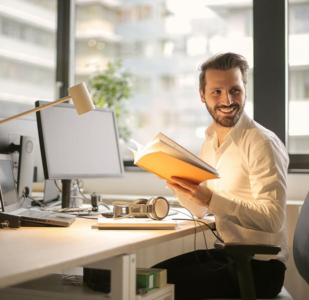 Male employee at desk, smiling.