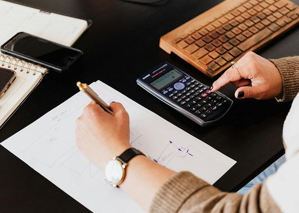Employee at desk calculating expenses.